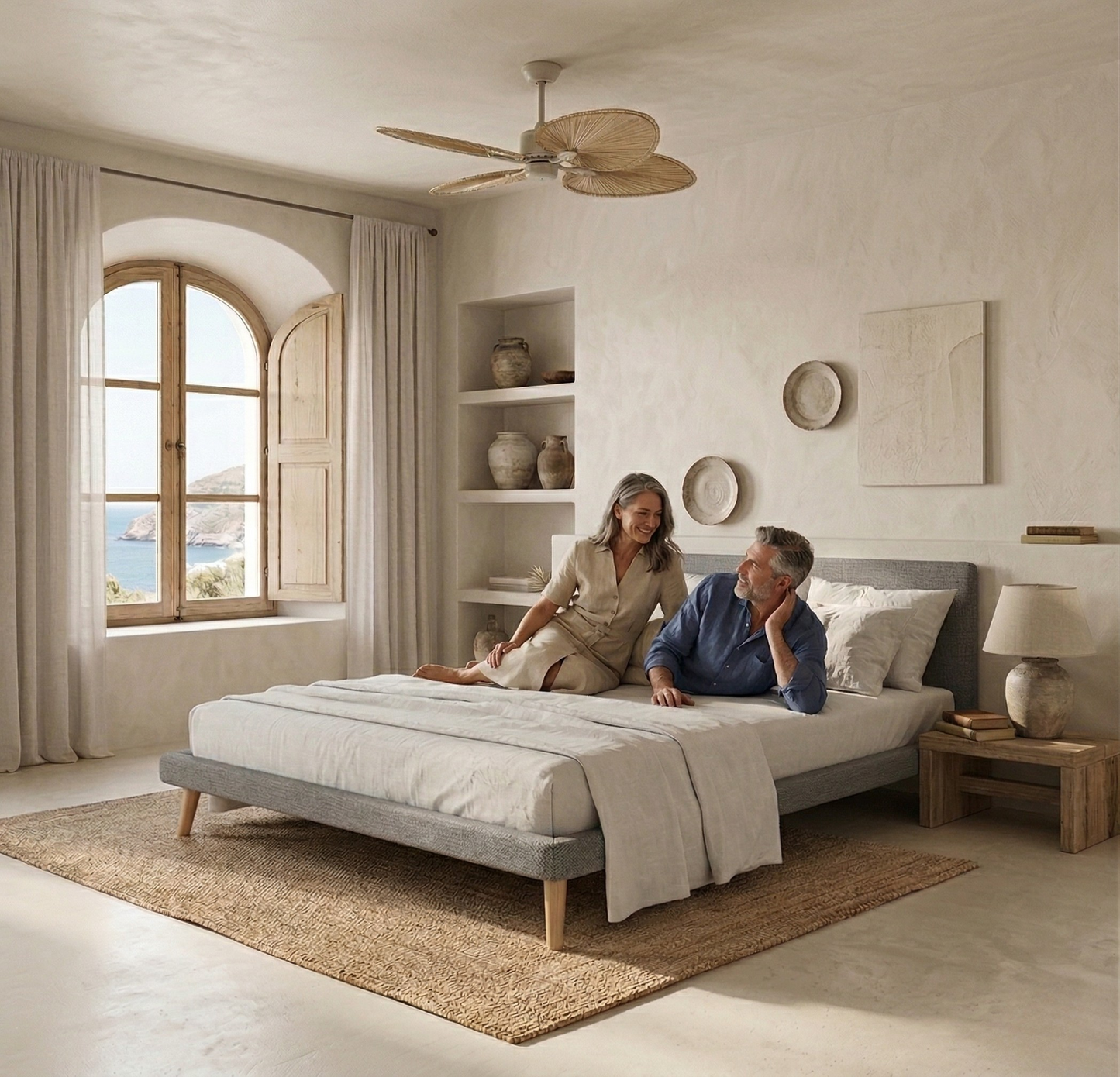 Base tapizada Kos color gris de Morfeo en habitación con dos personas sobre la cama.