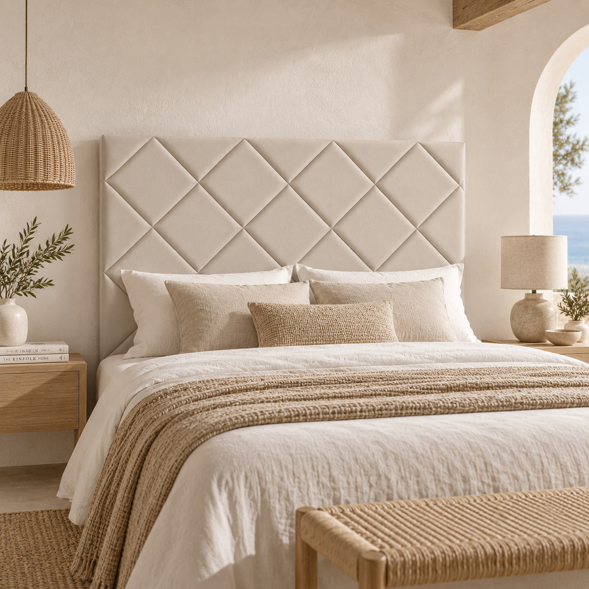 Cabecero Samos beige de Morfeo en un dormitorio mediterráneo con arco y vistas al mar.
