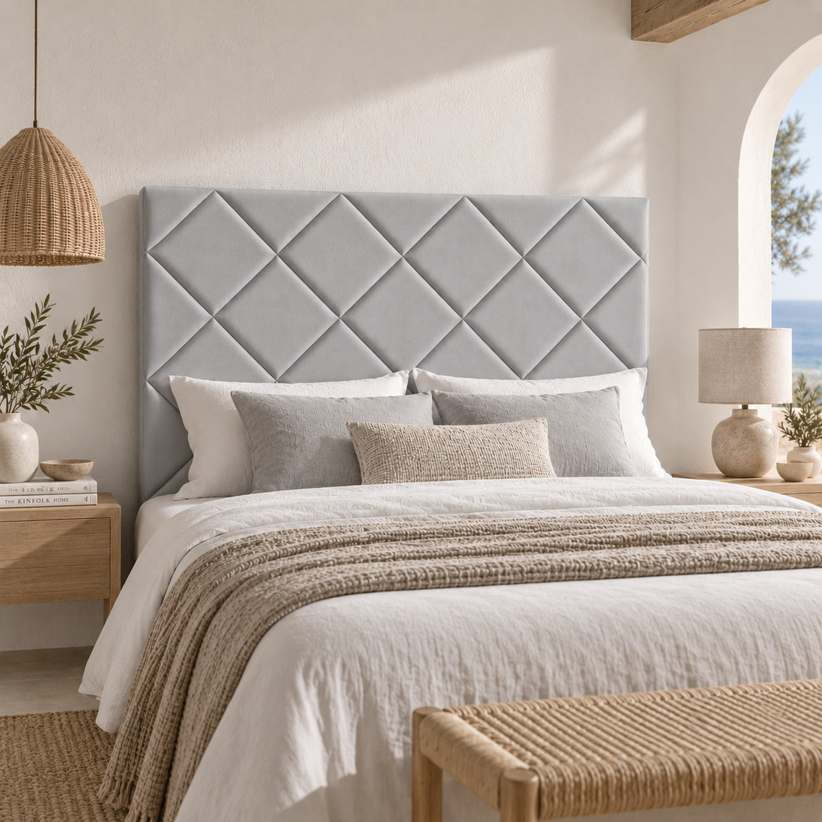 Cabecero Samos gris de Morfeo en un dormitorio mediterráneo con arco y vistas al mar.