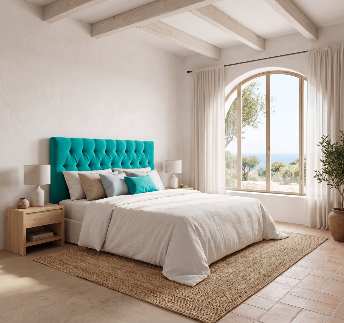 Cabecero tapizado Capy turquesa capitoné de Morfeo en un dormitorio mediterráneo con arco y vistas al mar.