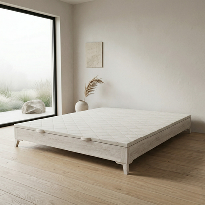 Canapé Niza color topo de Morfeo en dormitorio luminoso con suelo de madera y ventana amplia.