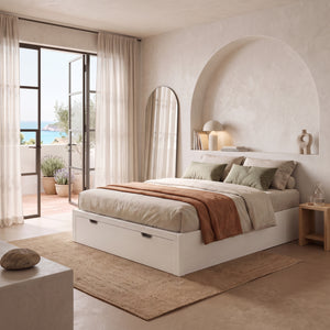 Canapé de madera Sofy color blanco de Morfeo en dormitorio mediterráneo con hornacina y vistas al mar.