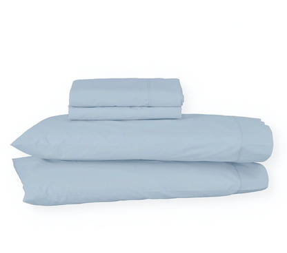 Juego de sábanas de algodón percal azul claro de Morfeo con fundas colocadas en almohadas visibles.
