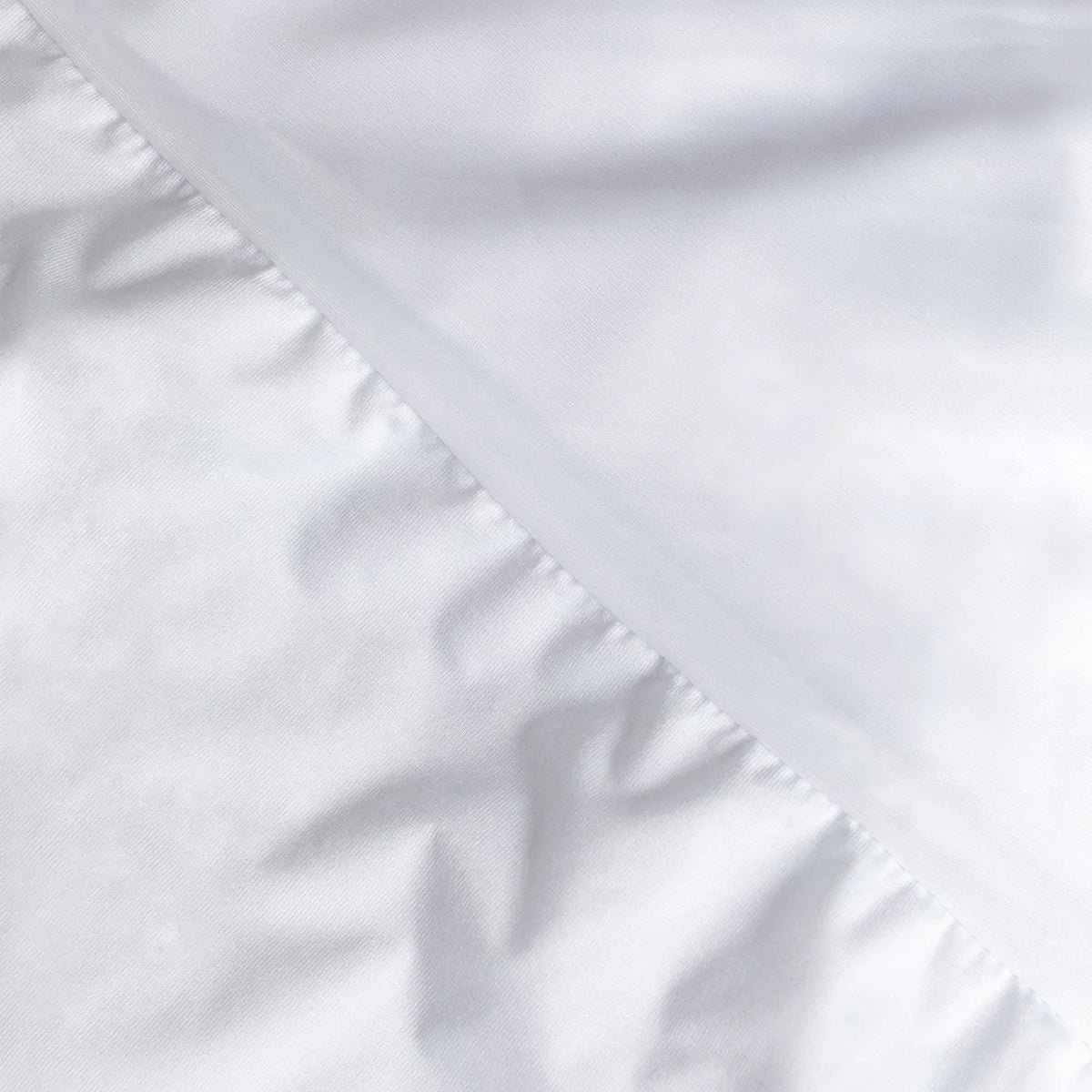 Detalle de la costura del borde y el faldón del protector de colchón Tencel de Morfeo.
