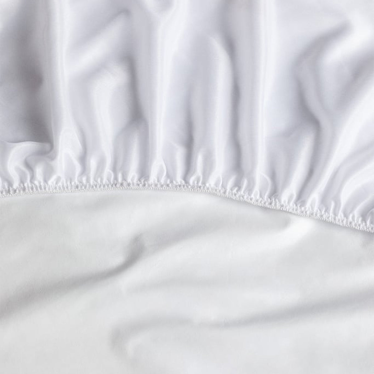 Detalle del faldón elástico perimetral del protector de colchón Tencel de Morfeo en color blanco.