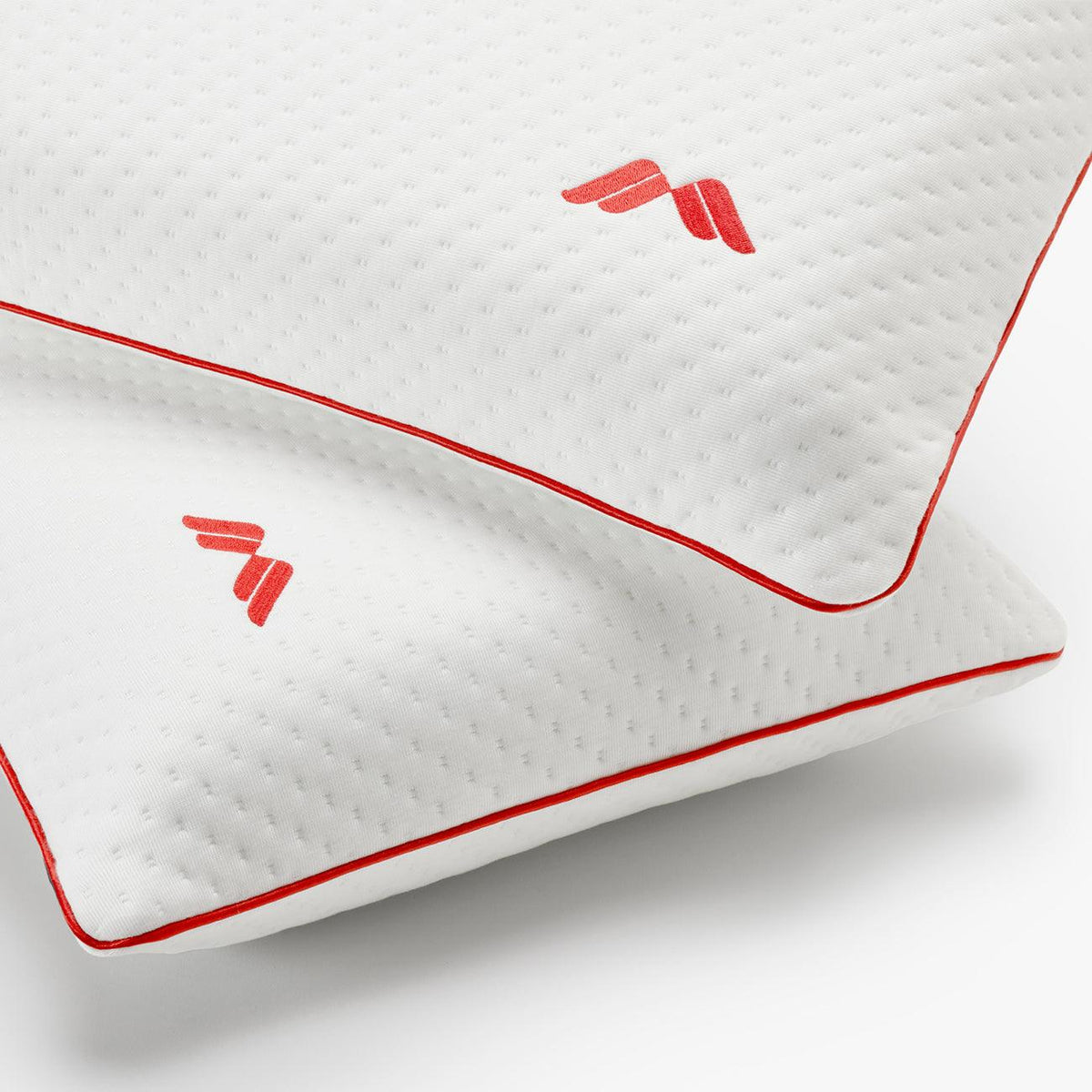 Detalle de dos almohadas viscoelásticas SojaVisco de Morfeo con logo bordado y ribete rojo.