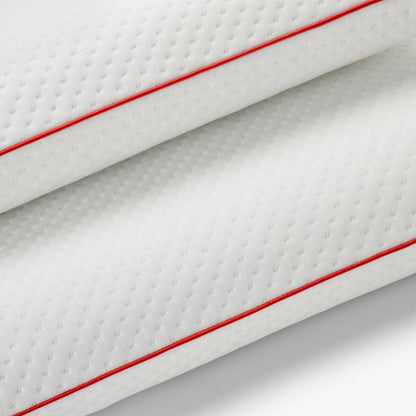 Primer plano del tejido de la funda con ribete rojo de la almohada viscoelástica SojaVisco de Morfeo.