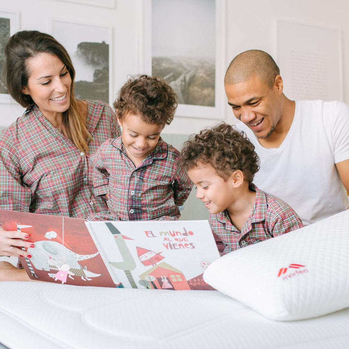 Familia leyendo un cuento en la cama junto a la almohada viscoelástica SojaVisco de Morfeo.