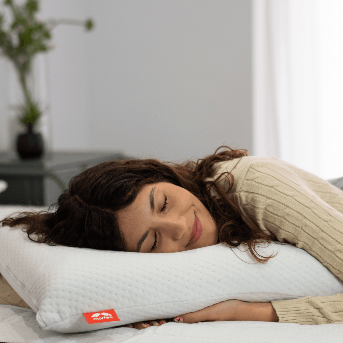 Mujer descansando con la cabeza apoyada en la almohada viscoelástica SojaVisco de Morfeo.