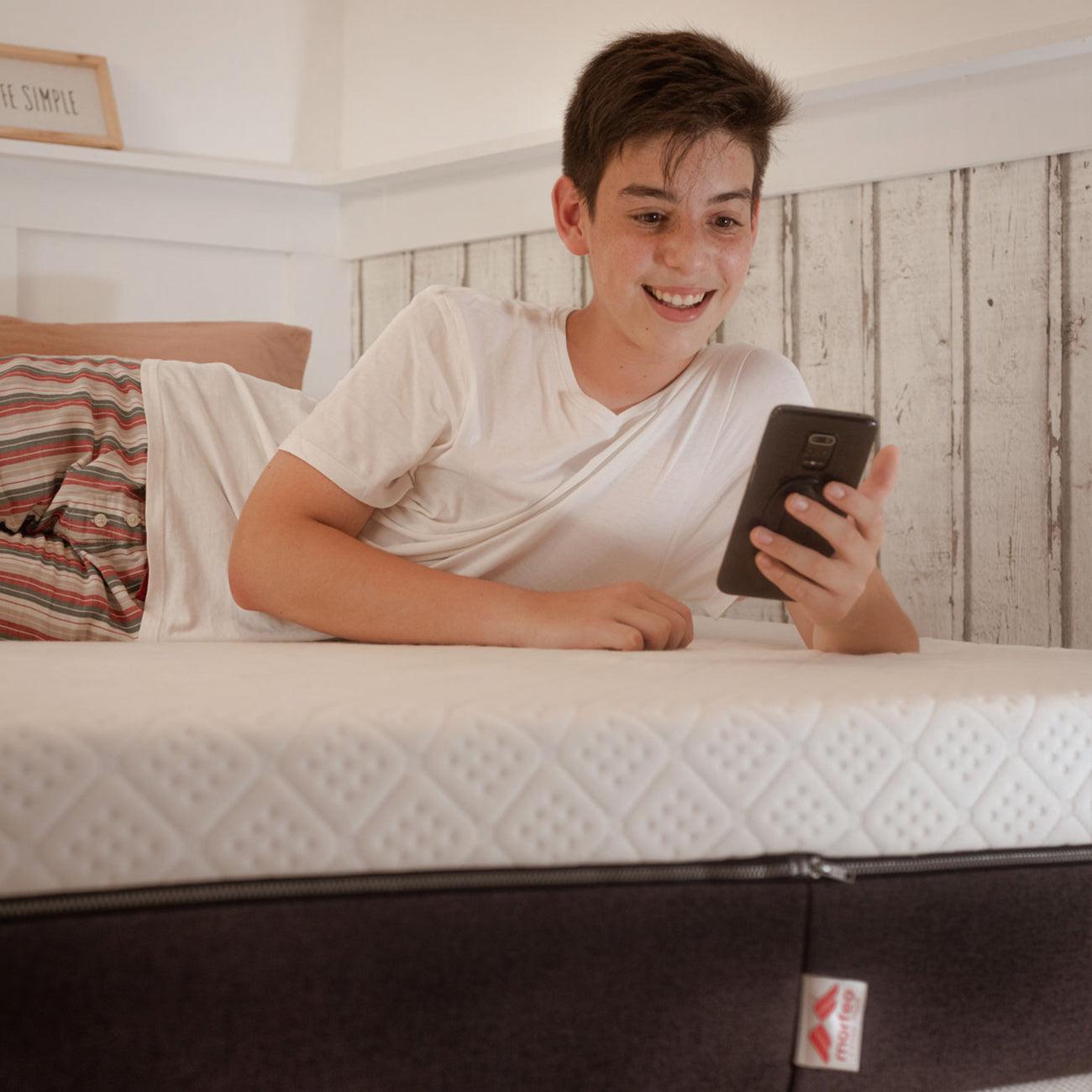 Niño descansando sobre el colchón Lite de Morfeo en cama juvenil.