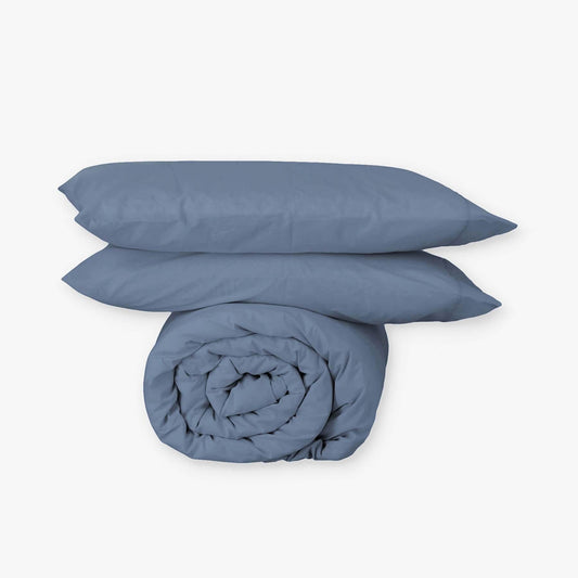 Funda nórdica EcoPercal de algodón orgánico color azul de Morfeo enrollada con dos fundas de almohada.