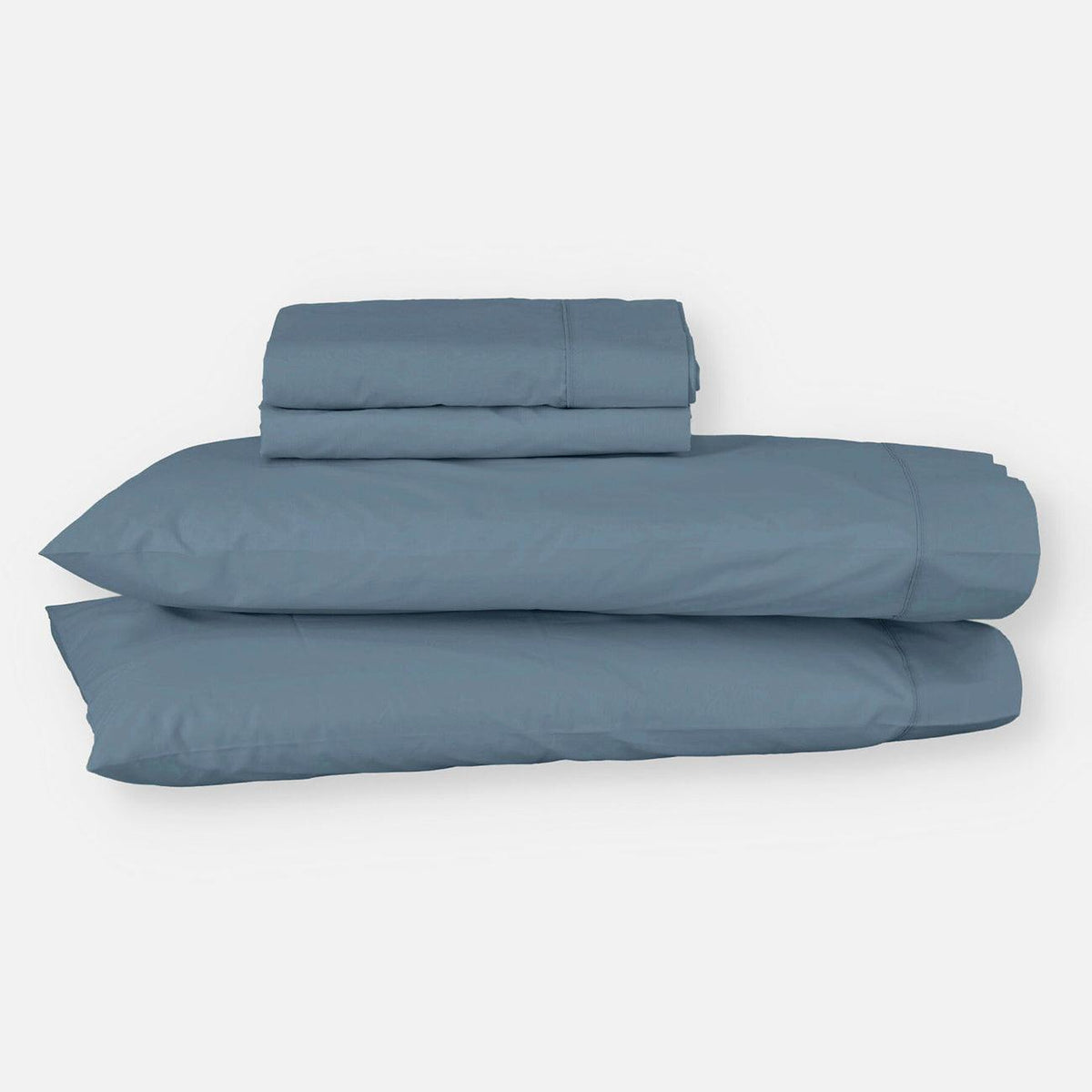 Juego de sábanas EcoPercal de algodón percal azul de Morfeo doblado con sus fundas de almohada sobre fondo blanco.