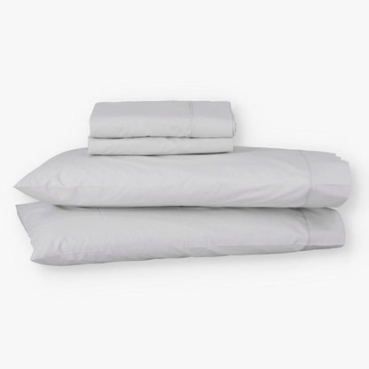 Juego de sábanas de algodón percal gris de Morfeo con fundas colocadas en almohadas visibles.